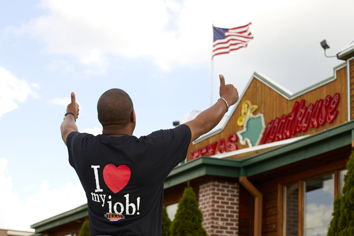 Texas Roadhouse team member giving two thumbs up outside the restaurant